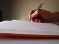 Hand holding a pen and writing on a notebook Royalty Free Stock Photo