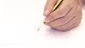 Hand holding a pencil  on white background . Close Up on a man`s hand writing on paper with a pencil  .Planning business Royalty Free Stock Photo