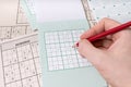 Hand is holding pencil and is solving sudoku crossword with numers Royalty Free Stock Photo