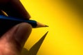 Hand holding pencil to write on the paper in shadow Royalty Free Stock Photo