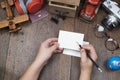 Hand holding pencil and white blnak paper notebook on wooden table