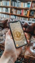 A hand holding a phone with the Bitcoin symbol on the screen