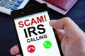 Hand is holding phone with irs scam calls Royalty Free Stock Photo