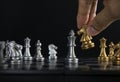 Hand holding a piece of chess knight or horse to win the game on black background. Checkmate, success, business strategy, Royalty Free Stock Photo