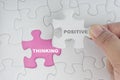 Hand holding piece of jigsaw puzzle with word POSITIVE THINKING. Royalty Free Stock Photo