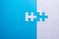 Hand holding piece of white puzzle on blue background. Business