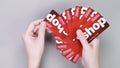 Hand holding pile of Costco wholesale red color gift cards on grey background. Shopping, gift card, shop. Gatineau QC Canada -