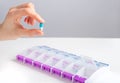 Hand holding pill capsule near tablet case, box Royalty Free Stock Photo