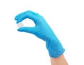 Hand holding a pill in medical gloves on a white background Royalty Free Stock Photo