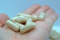 Hand holding pills, capsules. Closeup of a beige pills in one hand Royalty Free Stock Photo