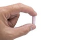 Hand holding a pink capsule pill isolated on white Royalty Free Stock Photo