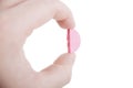 Hand holding pink pill