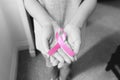 Hand holding pink ribbon on hand. Symbolic of breast cancer awareness Royalty Free Stock Photo