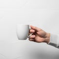 A hand holding a plain white ceramic mug against a white background Royalty Free Stock Photo