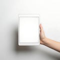 A hand holding a plain white rectangular object against a neutral background Royalty Free Stock Photo