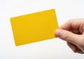 A hand holding a plain yellow rectangular card against a white background Royalty Free Stock Photo