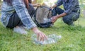 Hand holding plastic bottles waste, Couple picking up trash putting to the black garbage bag at Sunflower Park on Environmental Royalty Free Stock Photo