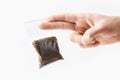 Hand holding Plastic transparent zipper bag with half Brewed coffee powder isolated on white, Vacuum package mockup with red clip.