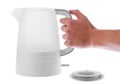 Hand holding an electric kettle with a stand next to a white isolated background Royalty Free Stock Photo