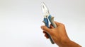 Hand holding pliers in blue and grey colored on a white background Royalty Free Stock Photo