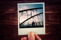 Hand holding polaroid postcard of two people silhouettes walking