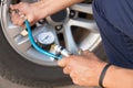 Hand holding pressure gauge for car tyre measurement Royalty Free Stock Photo