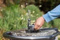 A hand holding a public drinking fountain. Water coming out splashing upward. Royalty Free Stock Photo