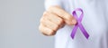 Hand holding purple Ribbon for Pancreatic, Esophageal, Testicular cancer, world Alzheimer, epilepsy, lupus, Sarcoidosis,