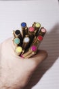 A hand holding a rainbow of colored pens on lined paper Royalty Free Stock Photo