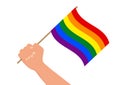 Hand holding and raising rainbow colored lgbt flag