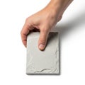 A hand is holding a rectangular light gray tile against a white background Royalty Free Stock Photo