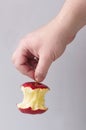 Hand holding a red apple core by the stalk Royalty Free Stock Photo