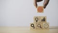 Hand holding red dartboard with arrow and stacking to icons cubes for setup business objective target concept