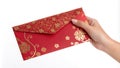 Hand holding a red envelope with gold decoration.Isolated image white background Royalty Free Stock Photo