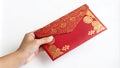 Hand holding a red envelope with gold decoration.Isolated image white background Royalty Free Stock Photo