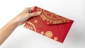 Hand holding a red envelope with gold decoration.Isolated image white background Royalty Free Stock Photo