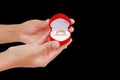 Hand holding red gift box with gold wedding ring isolated on black background Royalty Free Stock Photo