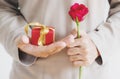 Hand holding red gift box, with rose flower, vintage tone