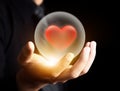 Hand holding red heart in crystal ball Royalty Free Stock Photo