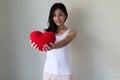 Hand holding red heart.Happy beautiful young woman holding red cushion heart shape smiling and looking at camera.love Royalty Free Stock Photo