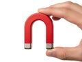 Hand holding red horseshoe magnet isolated on white background Royalty Free Stock Photo
