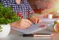 Hand holding red pen over blurred paperwork Royalty Free Stock Photo