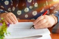 hand holding red pen over blurred paperwork for proofreading Royalty Free Stock Photo