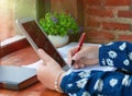 hand holding red pen over blurred paperwork for proofreading Royalty Free Stock Photo