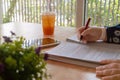 hand holding red pen over blurred paperwork for proofreading Royalty Free Stock Photo