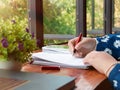 hand holding red pen over blurred paperwork for proofreading Royalty Free Stock Photo