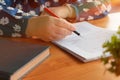 hand holding red pen over blurred paperwork for proofreading Royalty Free Stock Photo