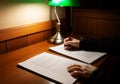 Hand holding red pen over blurred proofreading paper on wooden table Royalty Free Stock Photo