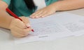 Hand holding red pen over proofreading paper Royalty Free Stock Photo