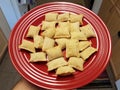 Hand holding red plate of frozen pizza rolls Royalty Free Stock Photo
